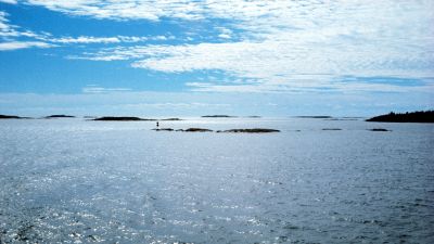En bild på ett blått hav, kobbar och skär och blå himmel.