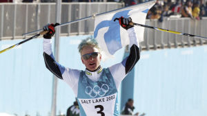 Samppa Lajunen juhlii olympiakultaa hiihtäen maaliin.