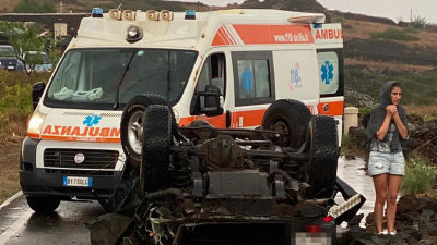 Åtminstone tio bilar slungades upp i luften av virvelvinden. Här har ambulansen kommit fram till en av bilarna.