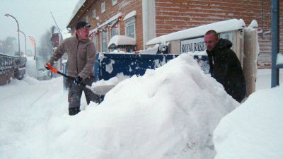 Två män skottar snö