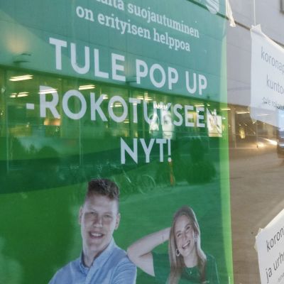 Pop up -koronarokotuksesta kertova juliste kauppakeskus Forumin ikkunassa Jyväskylän Asemakadulla. 