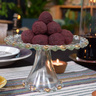 Ett bord som är dukat med ett kakfat med lila aroniabollar.