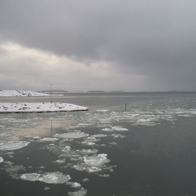 Vinterstrand och hav med isflak.