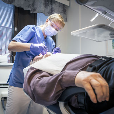 Tandläkare kollar tänderna på en patient