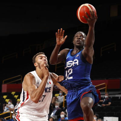 Jrue Holiday klädd i blått lyfter bollen mot luften.