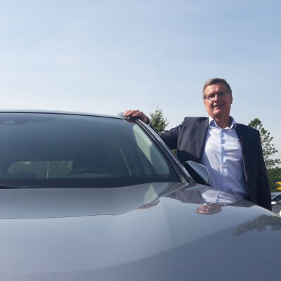 Vd Pekka Rissa vid Bilhandelns centralförbund poserar vid en bil. 
