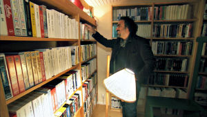 Alejandro Gonzales Inarritu tutkii Ingmar Bergmanin videohyllyä. Kuva dokumenttisarjasta Bergmanin videot.