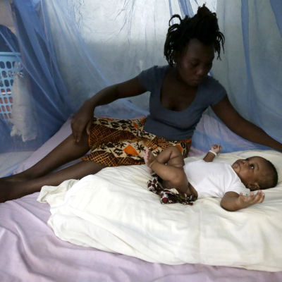 Nainen on suojannut lapsensa verkolla malariahyttysiltä Norsunluurannikolla. 