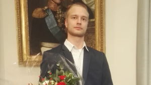 Jimmy Holmberg då han tar emot Gunnar Mickwitz-priset. Jimmy Holmberg håller en blombukett efter att ha fått Gunnar Mickwitz pris vid Helsingfors universtet.