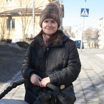 Elisabeth Glatz står ute på gatan med en barnvagn