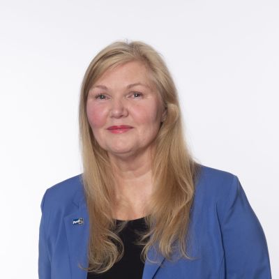 ett porträtt på en medelålders kvinna i blont hår som tittar in i kameran.