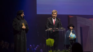 Mikael Agricola (Juhani Holma) och Sauli Niinistö under Reformationens 500-årsfest. Mikael Agricola (Juhani Holma), president Sauli Niinistö och Kristian Agricola (Otava Heiniö).