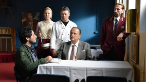 Khaled äter medan Wikström och restaurangpersonalen tittar på. Khaled (Sherwan Haji) sitter vid ett bord och blir serverad soppa, vid bordet sitter även Wikström (Sakari Kuosmanen) och runtom står tre personer och ser Khaled.