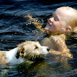 Koira ja lapsi uimassa