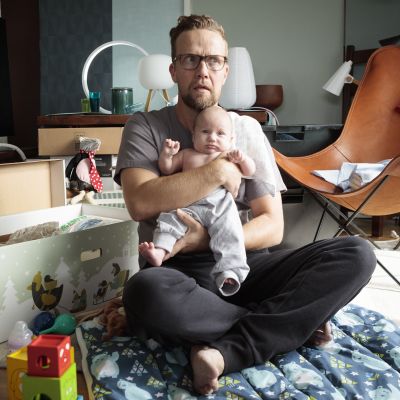Mies pitää lasta sylissään.