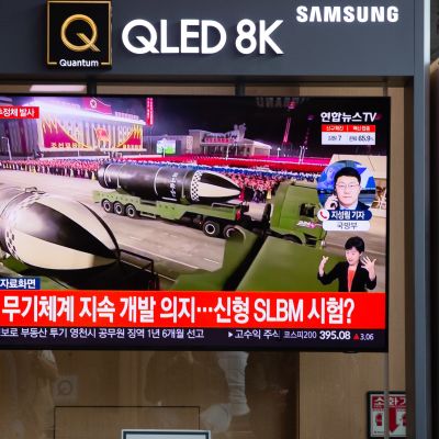 Nainen kulki televisioruudun ohi asemalla Etelä-Korean pääkaupungissa Soulissa. Uutisissa kerrotaan Pohjois-Korean juuri laukaisemasta ohjuksesta.