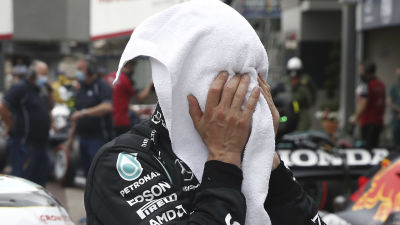 Valtteri Bottas begraver ansiktet i en handduk.