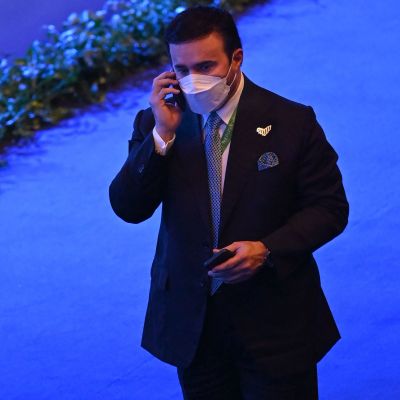 En man i iförd munskydd talar i telefon