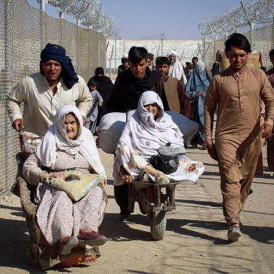 Afganistanilaiset ihmiset ylittävät rajan Pakistaniin.