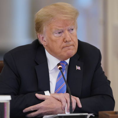 En äldre kostymklädd man med ljust hår sittande vid ett skrivbord. President Donald Trump i Vita huset den 26 juni 2020.