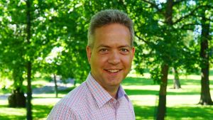 Lucas Snellman är ansvarig redaktör och skötte även tv-regin för Sommarsångerna. Lucas Snellman står leende i en grönskande park.