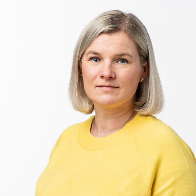 Studiofoto av producent Anki Karhu i en gul tröja.