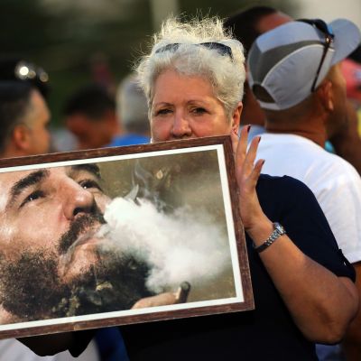 Nainen pitelee valokuvaa nuoresta Fidel Castrosta.