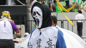 Demonstrationer är vanliga i huvudstaden Taipei. De som riktas mot Kina lockar mest deltagare. Taiwanesisk demonstration. Person iklädd skrämmande mask deltar.