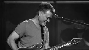 Eddie Van Helen. Gitarristen Eddie Van Halen spelar gitarr. Bilden är svartvit.