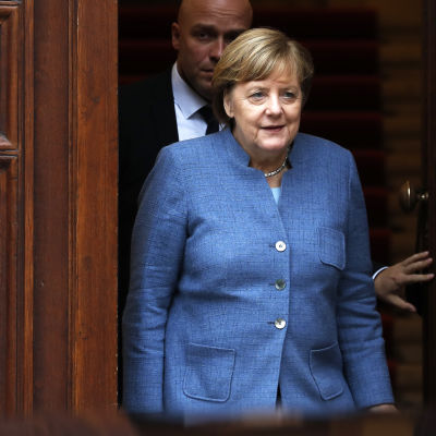 Angela Merkel går ut genom dörren efter en dag av regeringssondering.