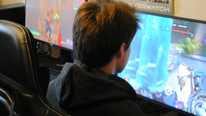E-sport kan rädda många som känner sig ensamma, eftersom det är enkelt att hålla kontakt med andra via datorn, säger Andersson. en ung kille spelar datorspel.
