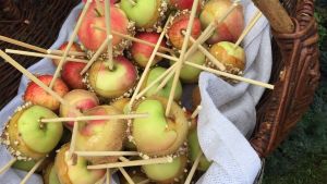 Gammeldagsgodis - glaserade äpplen på pinne. Äpplen på pinne till salu på marknaden.