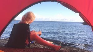 Lovis Roine är van att vistas i skärgården. barn sitter på en klippa och täljer en käpp
