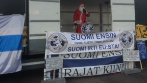 Demonstranter på Medborgartorget Invandrarfintlig julgubbe talar på självständighetsdagen i Helsingfors.