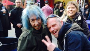 G.I.S.M.-fanit tuulettuvat keikan jälkeen. Kaksi ihmistä poseeraa kameralle, taustalla festivaalihumua.