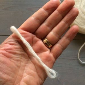 Hahtuvalanka rullataan käsien välissä paksummaksi tupoksi. villa, kääritetty kädellä