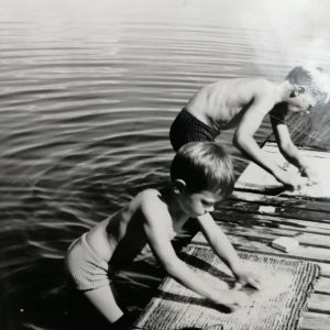 Jussi ja Timo Pakkasvirta pesevät mattoja Kivijärven laiturilla kuumana 1960-luvun kesäpäivänä.