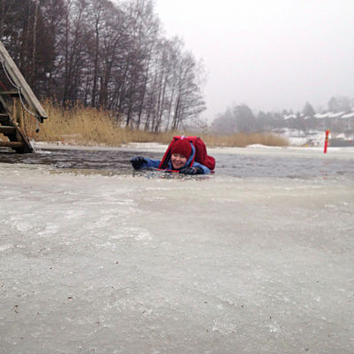 Yle nyheters reporter Sara Ekstrand provar hur det är att gå igenom isen.