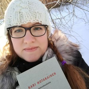 Kirjabloggaaja Heidi P. Kari Hotakaisen kirja Juoksuhaudantie kädessään