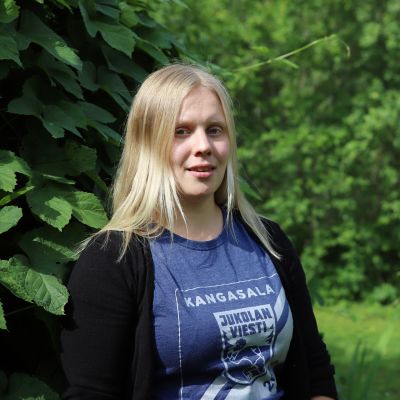 Susanna Valtonen hymyilee kesänvihreässä kuvassa.