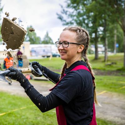 Juukan hiekan SM-kisoissa osallistuja Eeva Karhu heittää hiekkaa ilmaan.