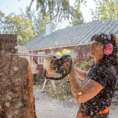 Kuvassa Ulla Haglund veistää puusta karhua