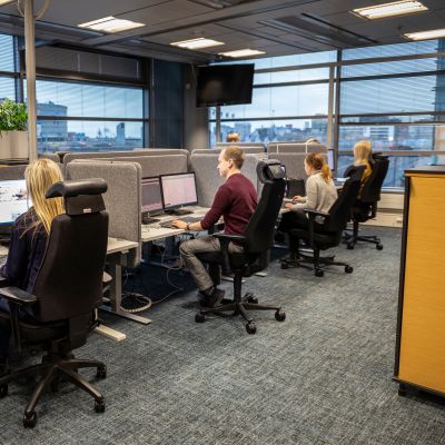 Danske Bankin chat-palvelua hoidetaan valoisassa avokonttorissa Helsingin Pasilassa. Töitä tehdään näyttöpäätteiden ääressä. Työvuorossa on kolme nuorta naista ja yksi mies.
