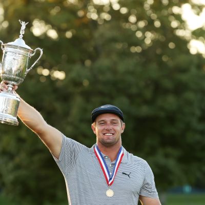 Bryson DeChambeau tuulettaa mestaruuspystin kanssa.