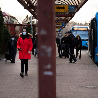 Kasvomaskeihin pukeutuneita matkustajia Itäkeskuksen bussiterminaalin edustalla.
