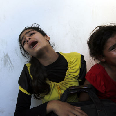 Palestinska flickor sörjer sin far som dog i den israeliska attacken mot en FN-skola i Gaza den 24 juli.