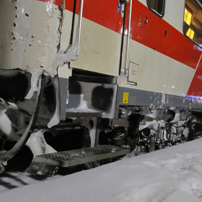 Tåg som står i snöväder.