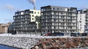 Nybyggda höghus på strande i Busholmen i Helsingfors sett från vattnet.