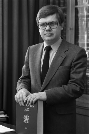 Christoffer Taxell är jurist i fjärde generation. Chrsitoffer Taxell poserar med Finlands lag.