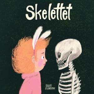 En bilderbokspärm där ett barn och ett skelett står vända mot varandra och tittar. Över dem boktiteln "Skelettet".